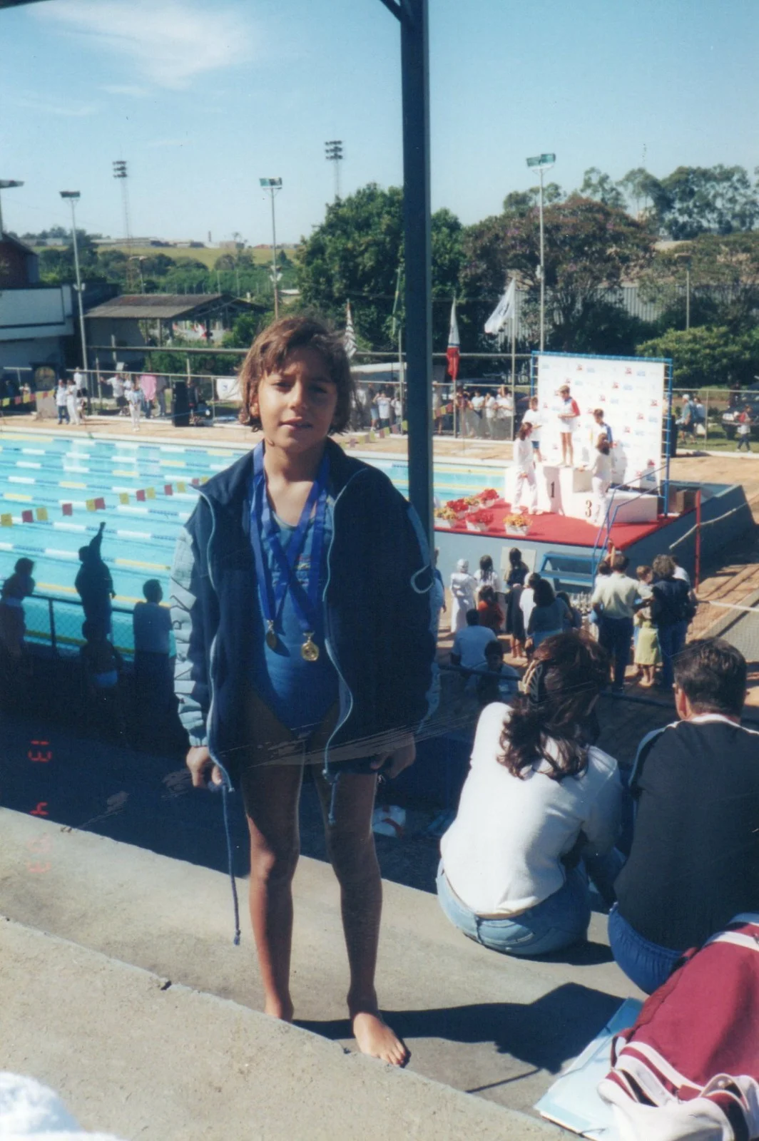Luísa criança em competição de natação com medalhas